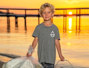 Boy holding trash by the beach