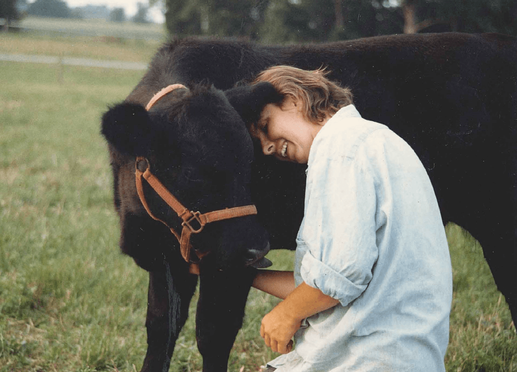 Harvey the cow snuggled up to Helga the human out on the green pasture. 